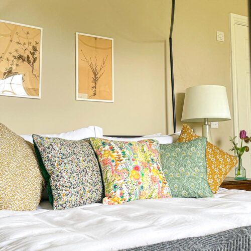 Liberty fabric cushions on bed